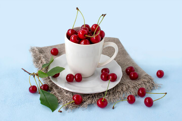 Fresh cherries in a white mug on a white background