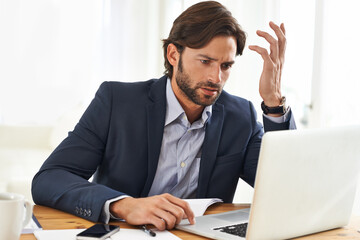 Hell do whatever it takes to get the job done. A handsome businessman working on his laptop.