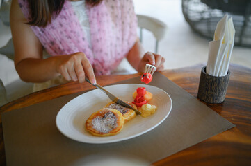 Young woman eating breakfast at the hotel