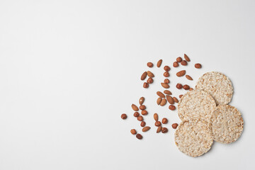 Fototapeta na wymiar Stack of rice cakes and nuts on white background. Healthy snacks