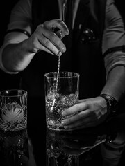 Delicious cocktail with alcohol served with garnish prepared by the bartender in the cocktail bar in dark colors