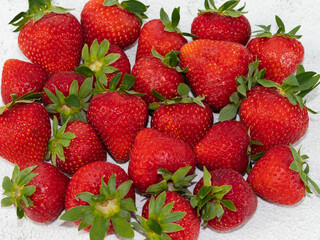 many strawberries close up view on white marble background