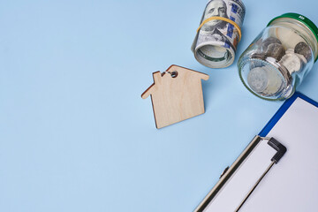 Close up house model with coin and money on blue background for planning of home loan mortgage...