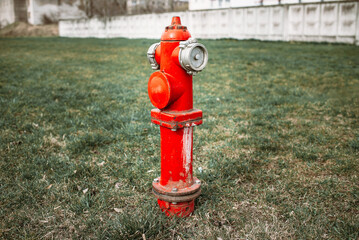 Single red fire hydrant on green lawn.Autumn,spring,summer day.Toned.