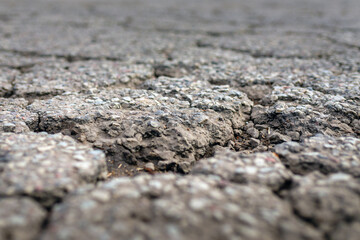 Empty damaged alphalt road in the street.Blurred foreground and background.Closeup.Selective focus.