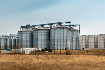 Modern complex for drying,cleaning and storage a grain.Overcast blue cloudy sky spring,autumn background.