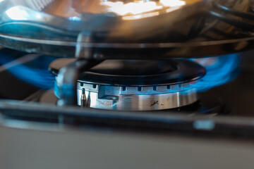 Combustion of household gas on a gas stove, gas energy saving concept.Closeup.