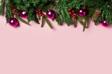 Christmas background with fir tree and decor on pink backgraund. Top view with copy space