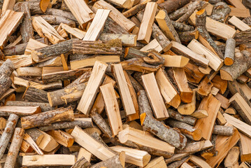 A pile of stacked firewood, prepared for heating the house. Firewood for ready heating in winter.Chopped firewood.environment background.