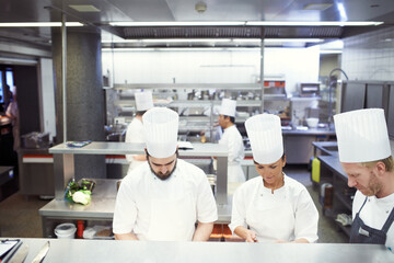 All hands on deck for service. Shot of the inner working of a professional kitchen.