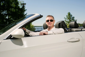 Handsome man in sunglasses in cabriolet. Luxury life