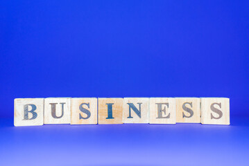 BUSINESS word written on wood blocks number cubes put on blue background.Copy space.