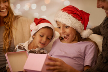 Just what I wanted. A little girl unwrapping a Christmas present while surrounded by her family.