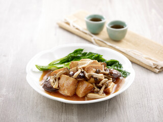 Braised Firm Tofu with Assorted Mushrooms with chopsticks served in a dish isolated on mat side view on grey background