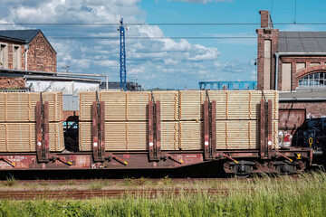 Bereits zugeschnittenes Holz liegt auf einem offenem Güterwagen