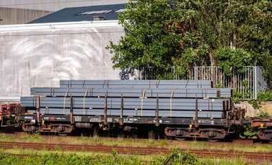 Metallteile liegen auf einem offenen Güterwagen bereit.
