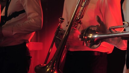 Close-up of a trumpet player standing on stage filled with red flashing light