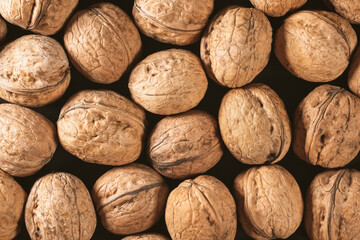 Background of fresh walnuts in the shell at the market. Healthy organic food. Top view