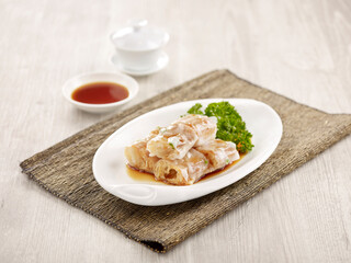 Steamed Rice Rolls with Dough Fritter Filling with chopsticks served in a dish isolated on mat side view on grey background