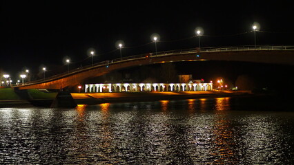 Fototapeta na wymiar Historical monument. Night view of the Volkhov River, the Gostiny Dvor Arcade and the Great Bridge. Veliky Novgorod, Russia.