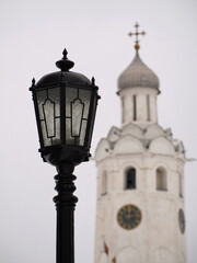 Fototapeta na wymiar Historical landmark. Vintage lantern against the background of the Clock Tower, Novgorod Kremlin. Veliky Novgorod, Russia.
