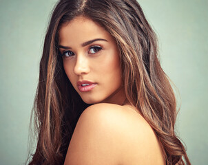 Fototapeta premium Beauty thats fresh and perfectly natural. Studio portrait of a beautiful woman with long locks posing against a grey background.