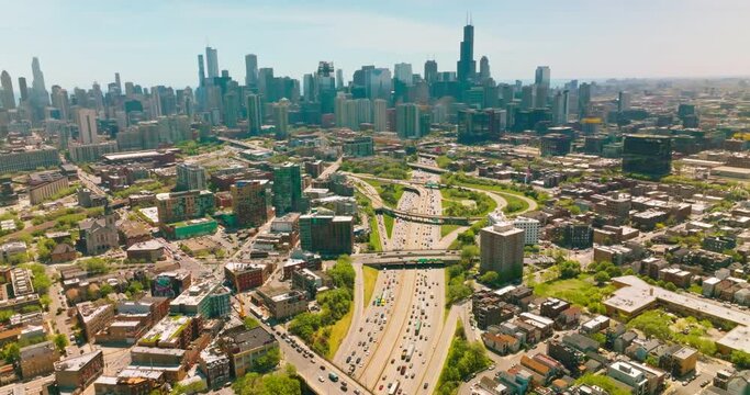 Huge multi-lane road with lots of cars moving along. Sunny cityscape of Chicago at daytime. Skyscrapers at backdrop.