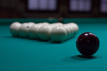 Russian billiard:  black and white balls on green table