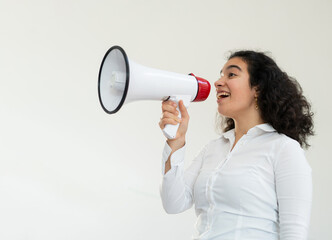 Beautiful business woman with curly hair holding a megaphone. High quality photo