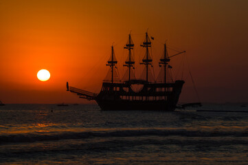 Pirate ship in the mediterranean sea. Evening landscape with a ship at sunset