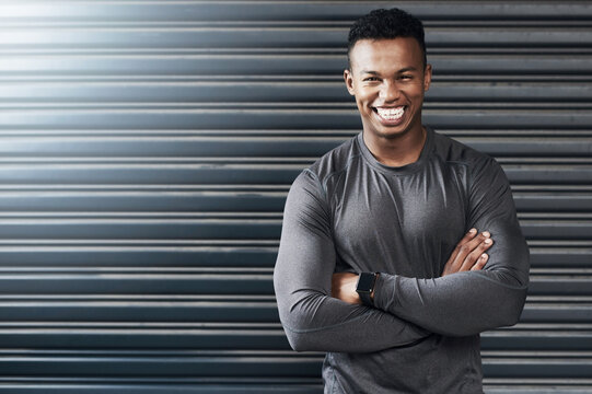 I earned results through strong determination. Portrait of a sporty young man standing with his arms crossed against a grey background.