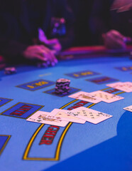 Poker table view with a pack of cards, tokens, alcohol drinks, dollar money and group of gambling rich wealthy people playing poker in casino, with croupier