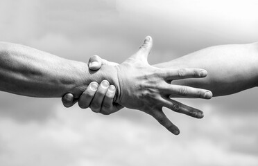 Close up help hand. Helping hand concept, support. Friendly handshake. Two hands, shaking hands. Black and white
