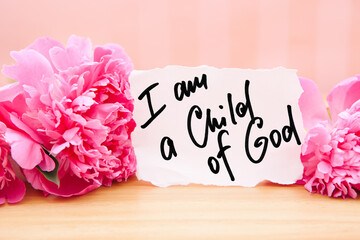 I am a child of God - christian calligraphy lettering on card with pink peony flower, biblical verse and religion concept