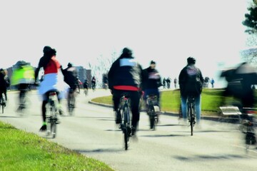 Fototapeta na wymiar Cyclists riding small hill in urban setting with motion blur