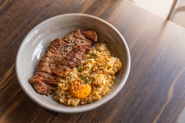 selective focus, beef fat garlic ​fried rice with​ ​beef steak ​and topping with pickled...