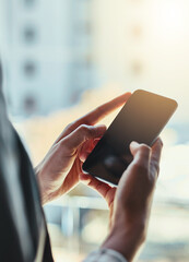 Staying in touch. Shot of an unrecognizable young businesswoman using her cellphone in the office.