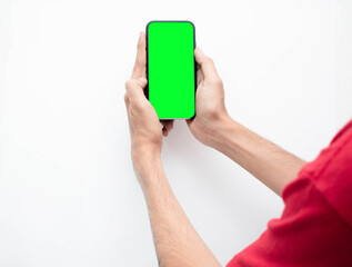 Mano de un hombre joven con su telefono inteligente tomando una foto con fondo verde en aislado...