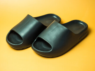 A pair of slides with an open toe pillow isolated on a colored background. Soft slippers
