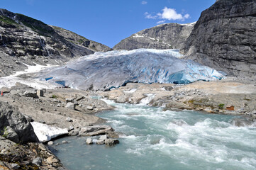 The huge Jostedalsbreen glacier in the middle of the rocky mountains above a lake in Norway