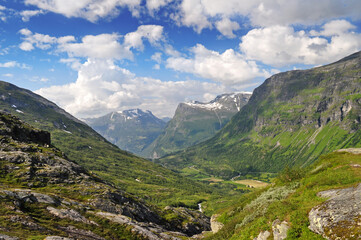 Fototapeta na wymiar Panorama of high mountains with a deep valley in the north of Europe in Norway in the town of Geiranger.
