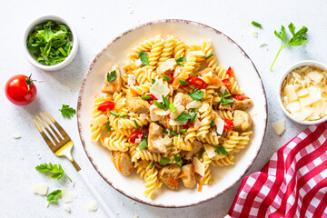Pasta with turkey or chicken, vegetables and parmesan. Top view at white.