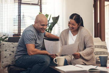 Youd be smiling too if you saved like they did. Shot of a young couple going over paperwork at home.