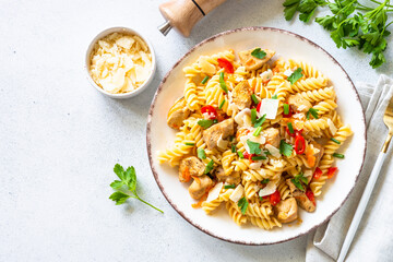 Pasta with turkey meat, vegetables and parmesan on white table. Top view with copy space.