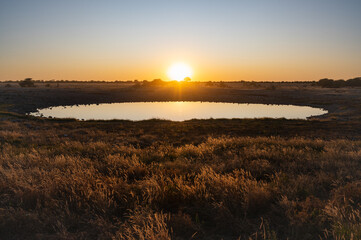 Beautiful sunset over the waterhole of Okaukuejo in Etosha National Park, Namibia