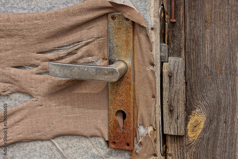 Canvas Prints one old rusty brown metal doorknob on a tattered fabric door outside