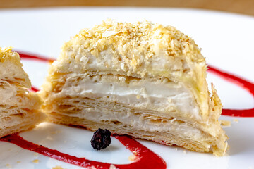 Close up Puff pastry layered cake Napoleon with vanilla cream filling on a cyan blue dishes. Macro...