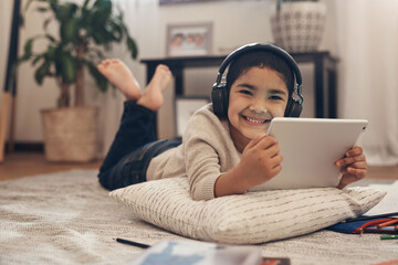 Cant get to the library Enter the audiobook. Shot of an adorable little boy using a digital tablet...