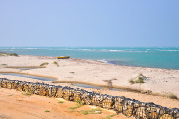 Lonely boat in the middle of the sandy shore near the ocean at Arichal Munai, Dhanushkodi, Tamil Nadu, India