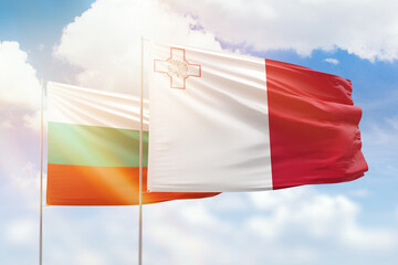 Sunny blue sky and flags of malta and bulgaria